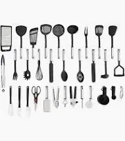 Un ampio set di utensili da cucina neri e in acciaio inossidabile, disposti su tre file su sfondo bianco.