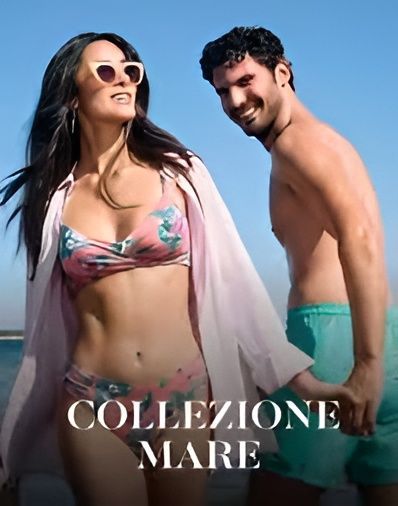 Una coppia in costume da bagno si tiene per mano su una spiaggia assolata, con sovrapposta la scritta