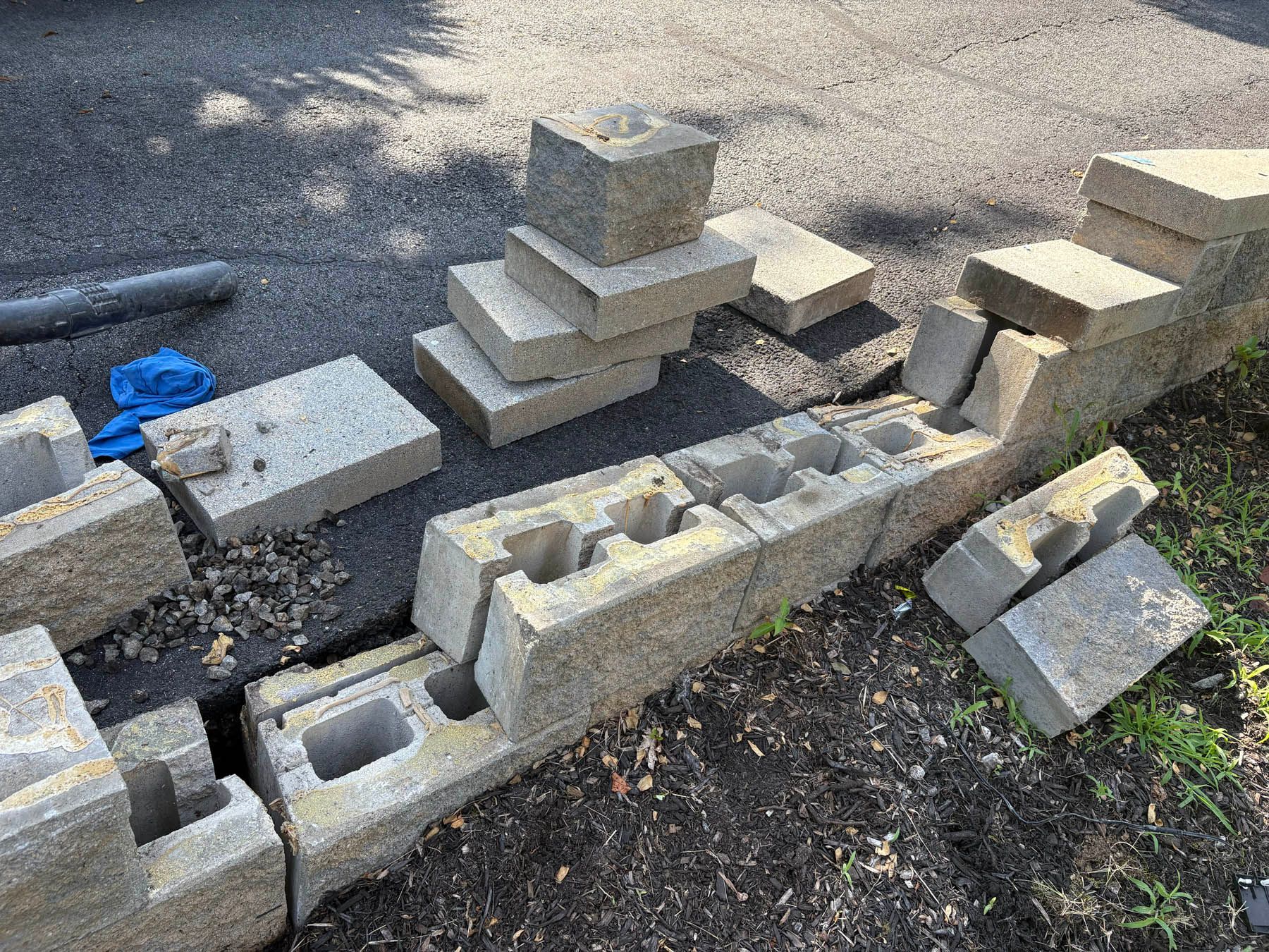 Concrete blocks arranged on the ground; some stacked, some in a line, and some broken.