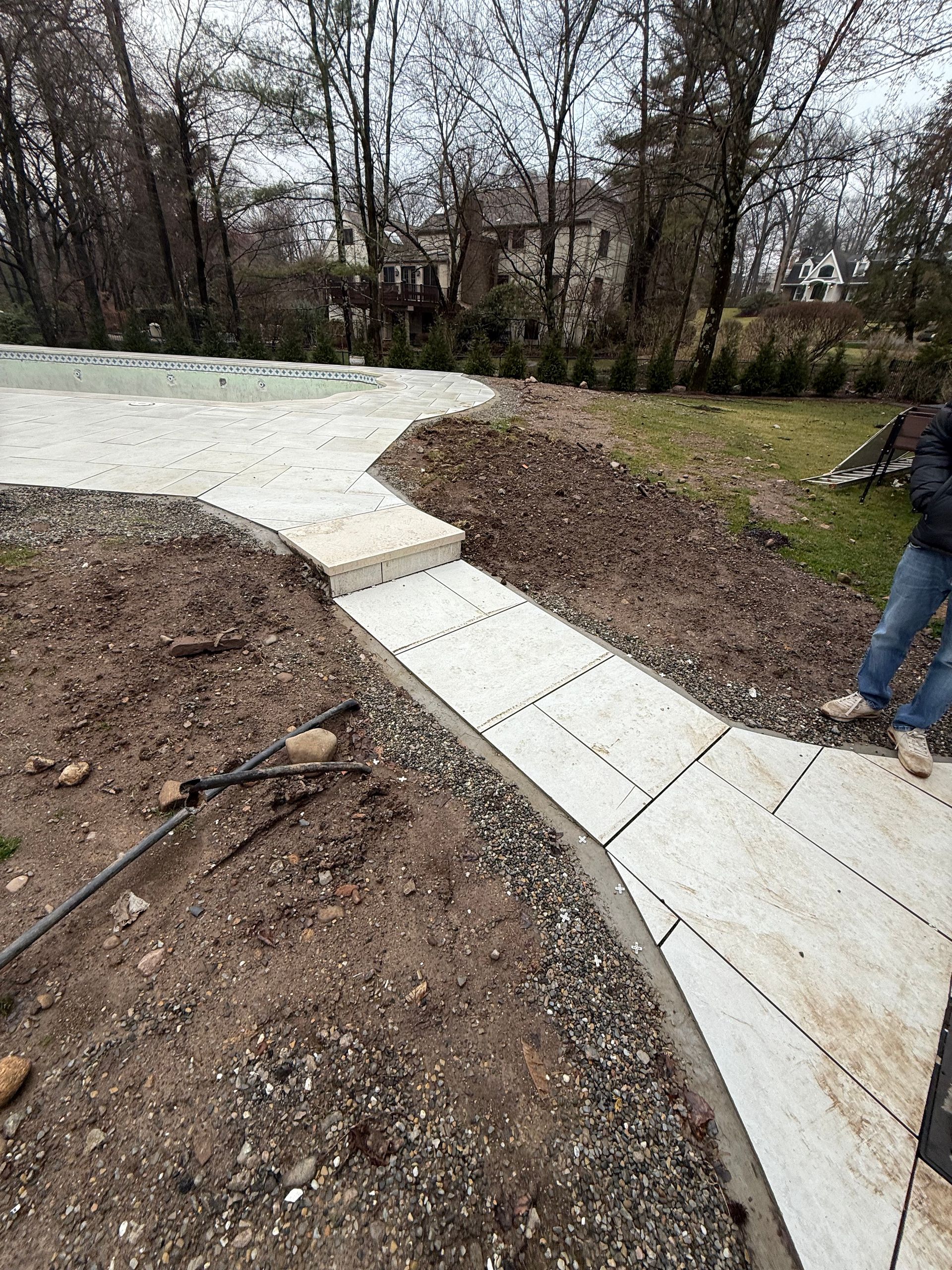 Stone pathway with steps, bordered by dirt and gravel, leading to an unknown destination.