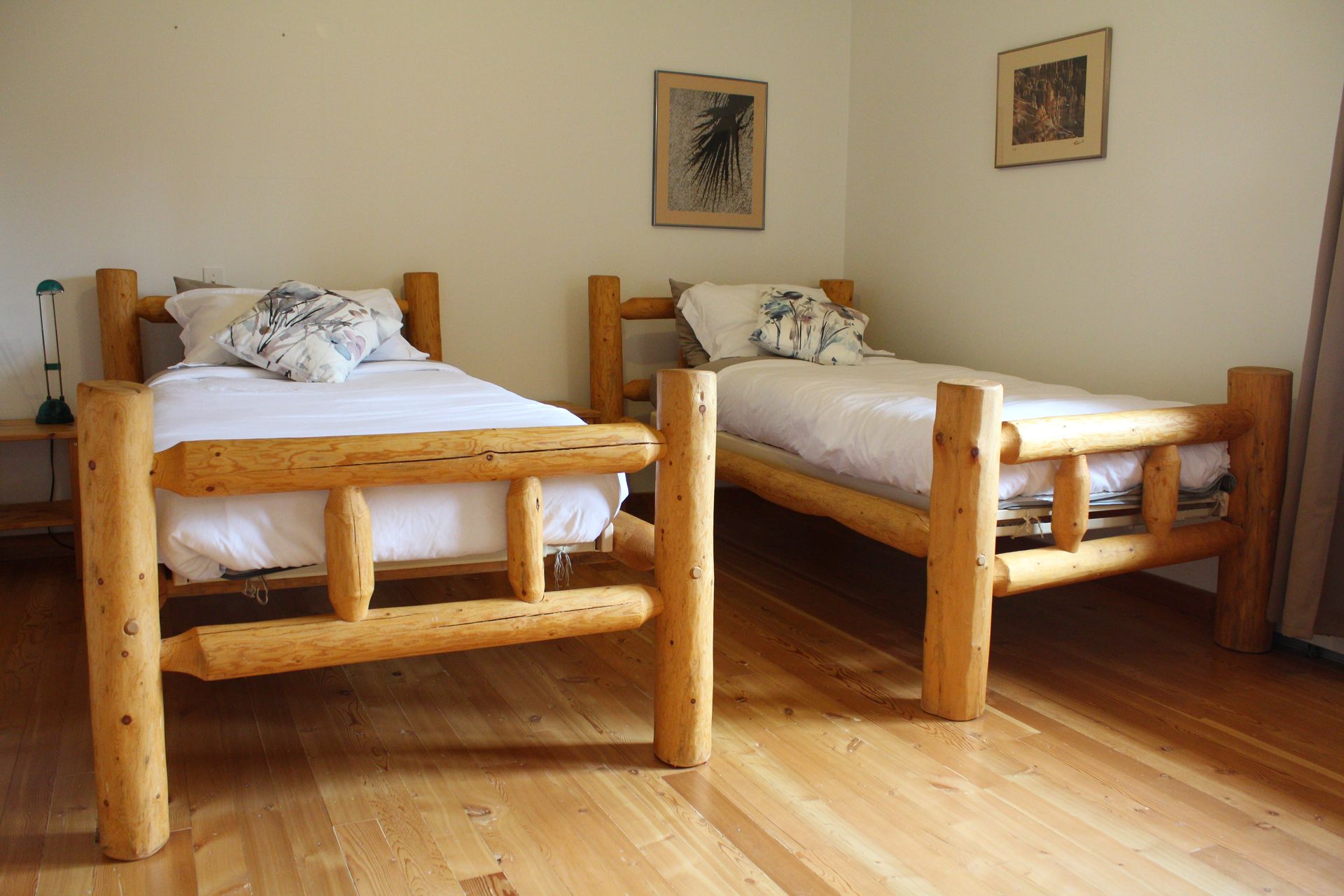 Two log beds are sitting next to each other in a bedroom.