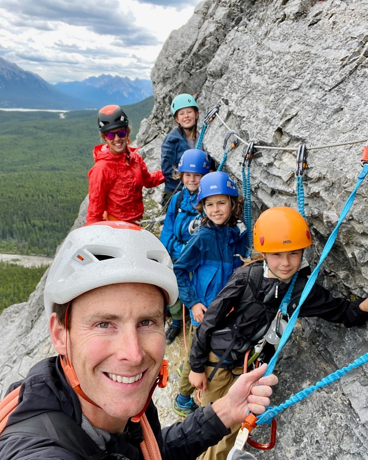 A group of people are standing on top of a rocky mountain.