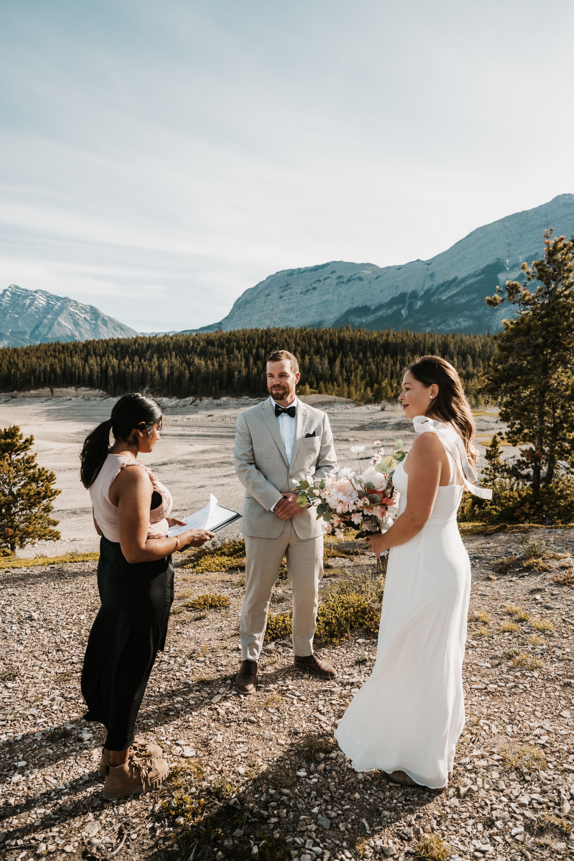 A bride and groom are getting married in the mountains.