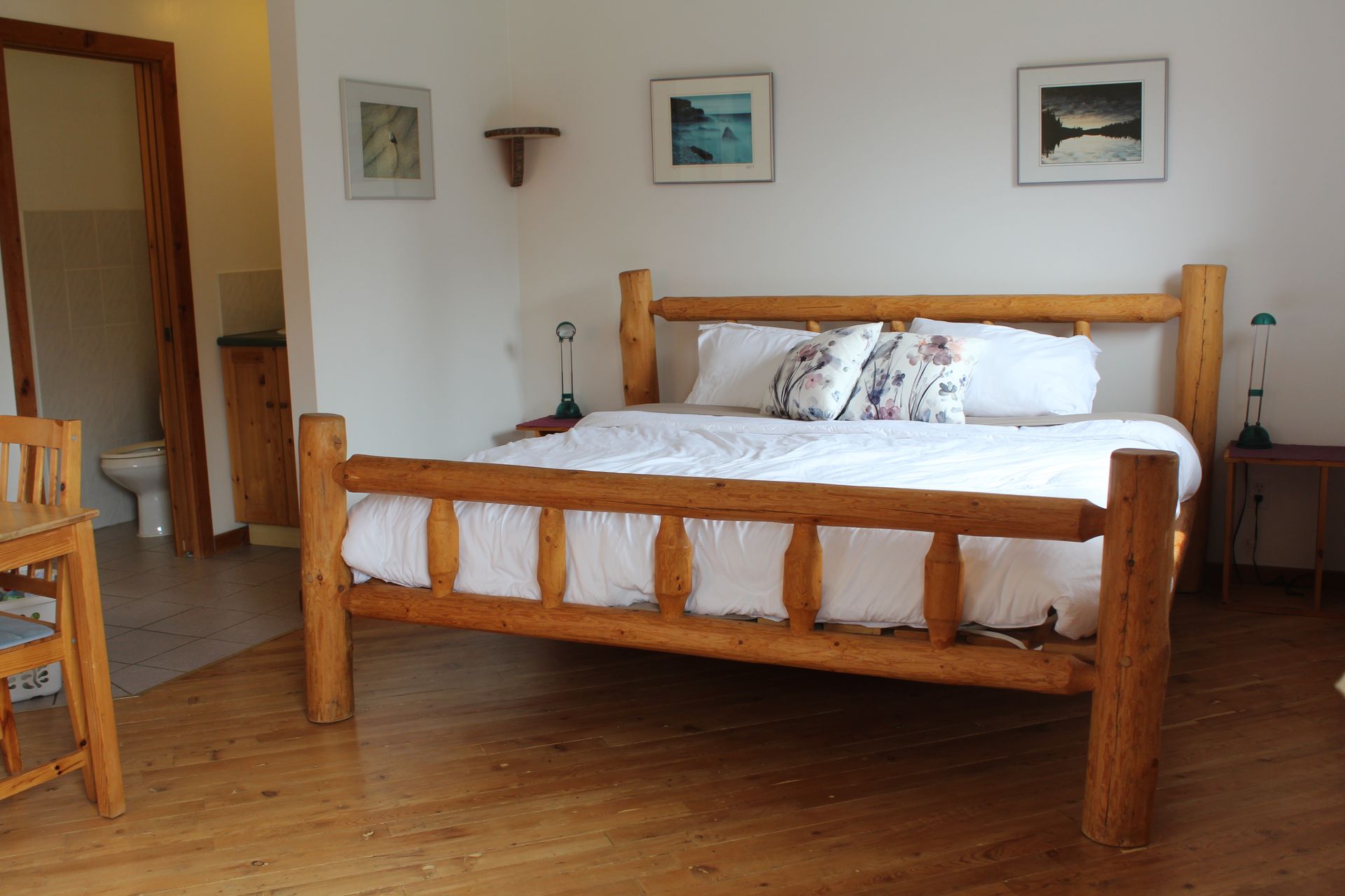 A bedroom with a wooden bed and a chair