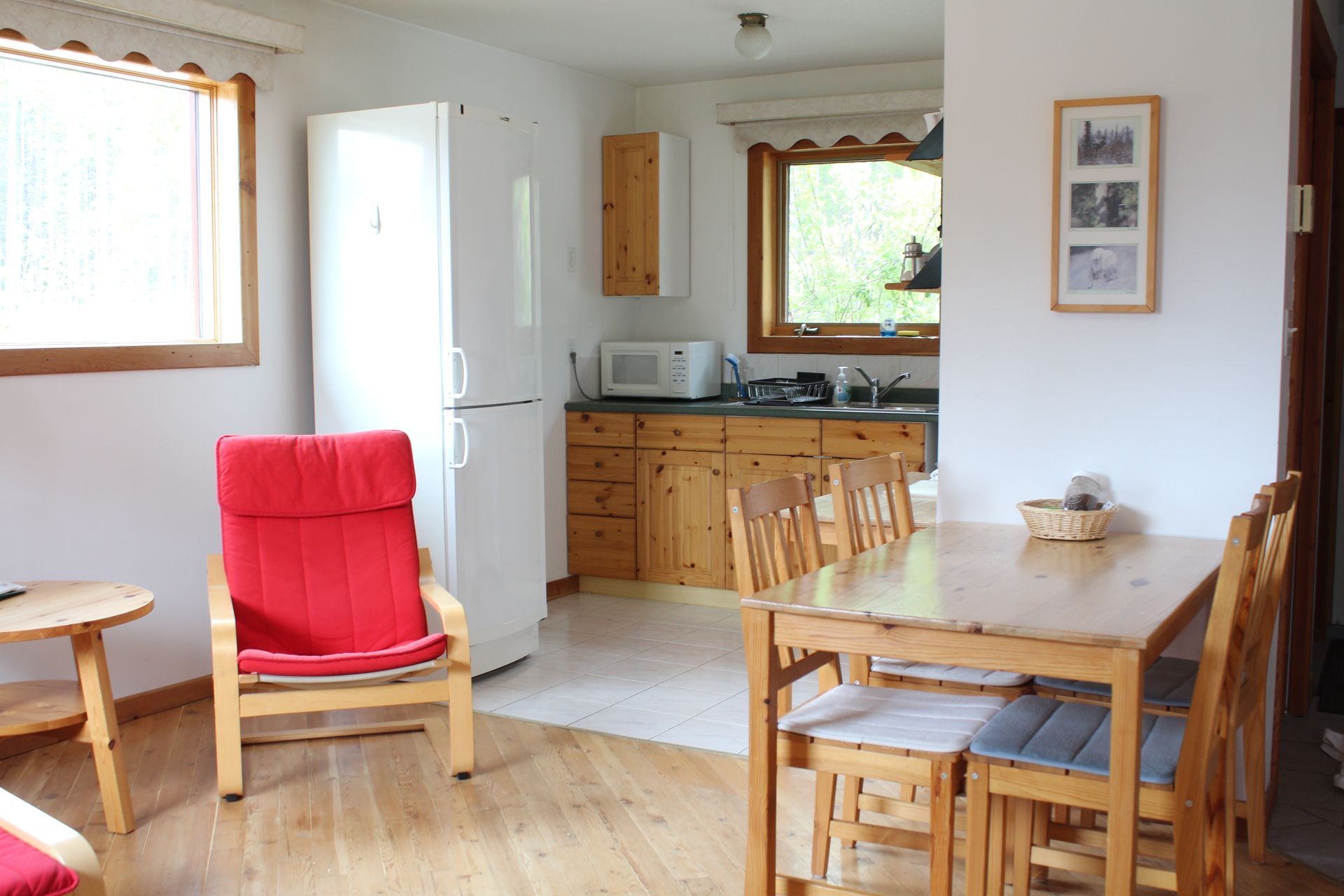 A living room with a table and chairs and a refrigerator