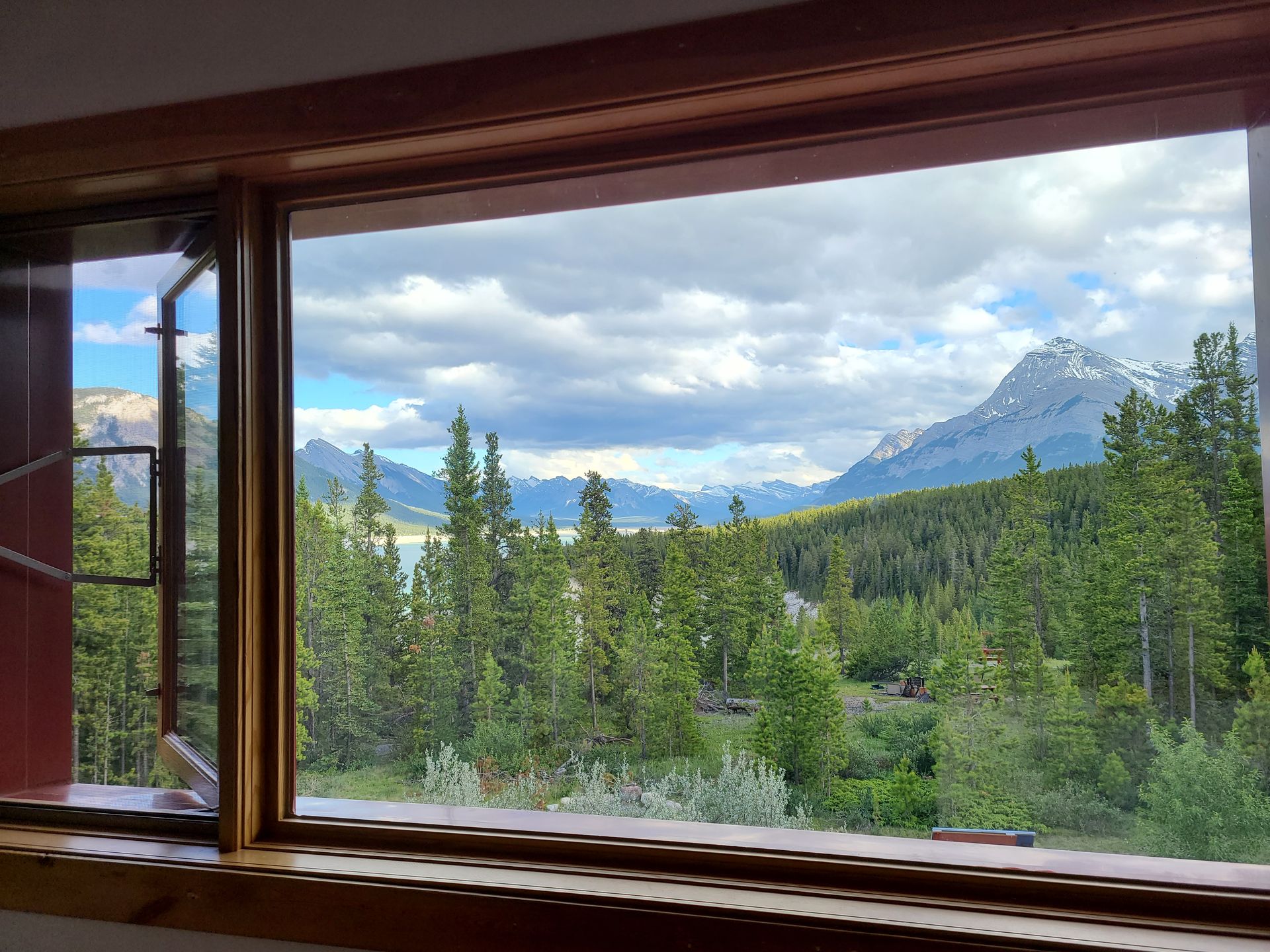 A window with a view of a forest and mountains