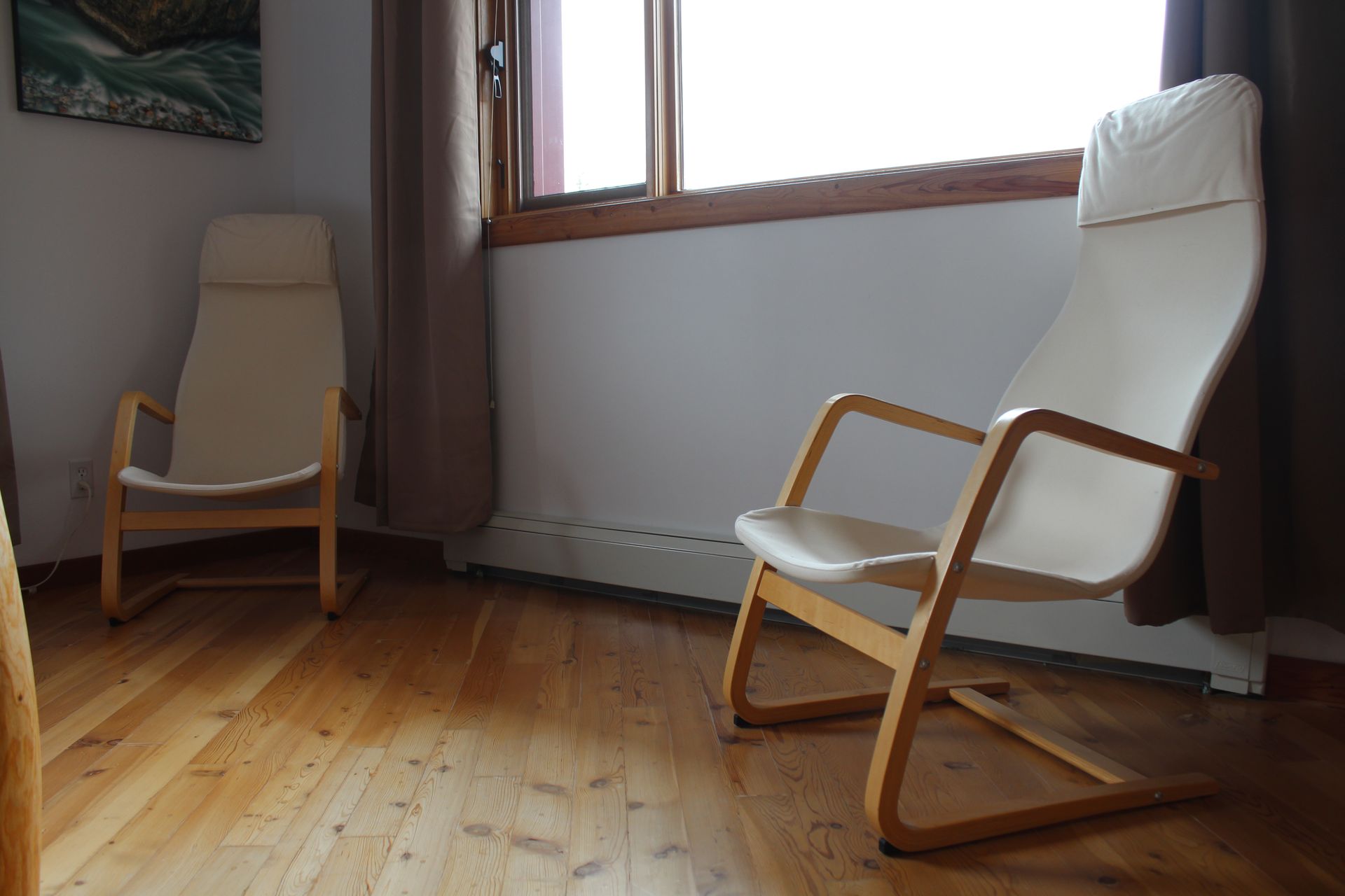 Two chairs are sitting in a room next to a window.