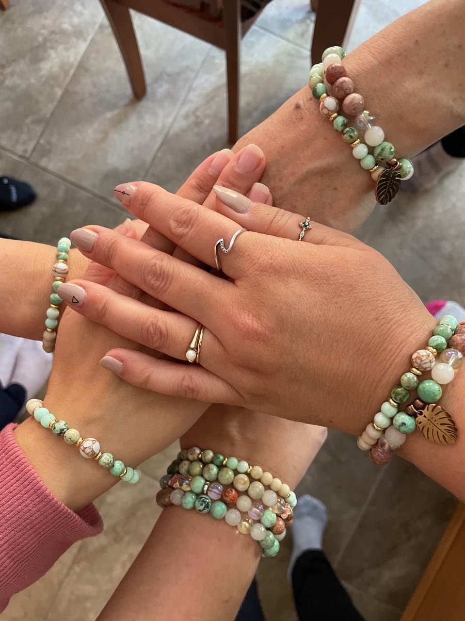 A group of women wearing bracelets and rings are stacked on top of each other.