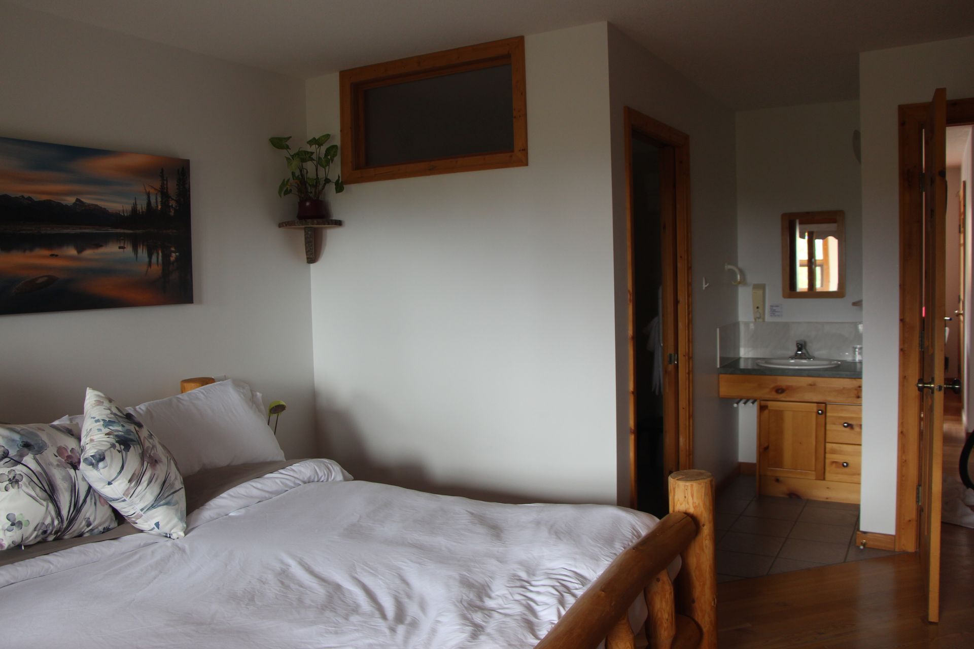 A bedroom with a bed and a painting on the wall