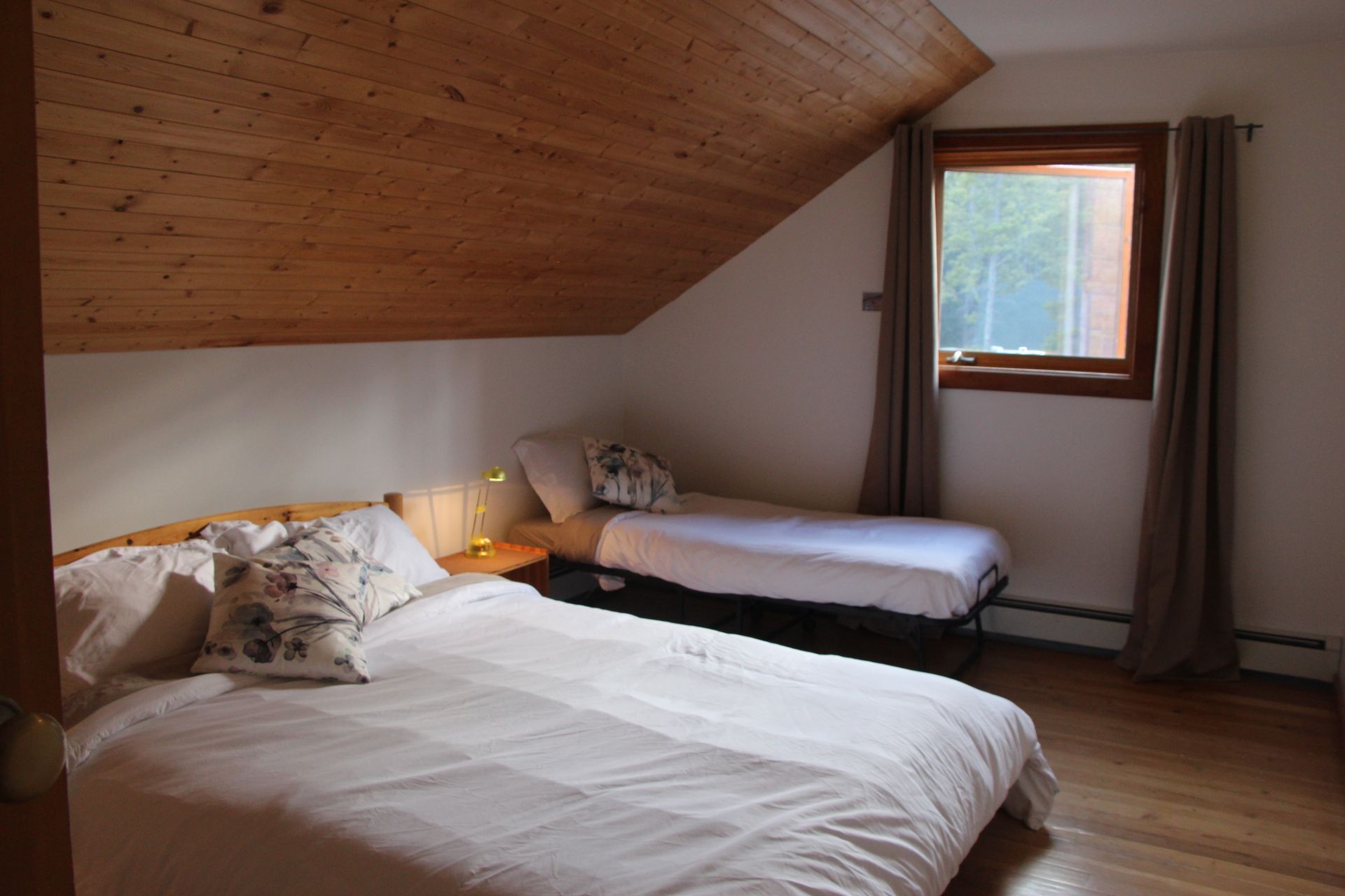 A bedroom with two beds and a window