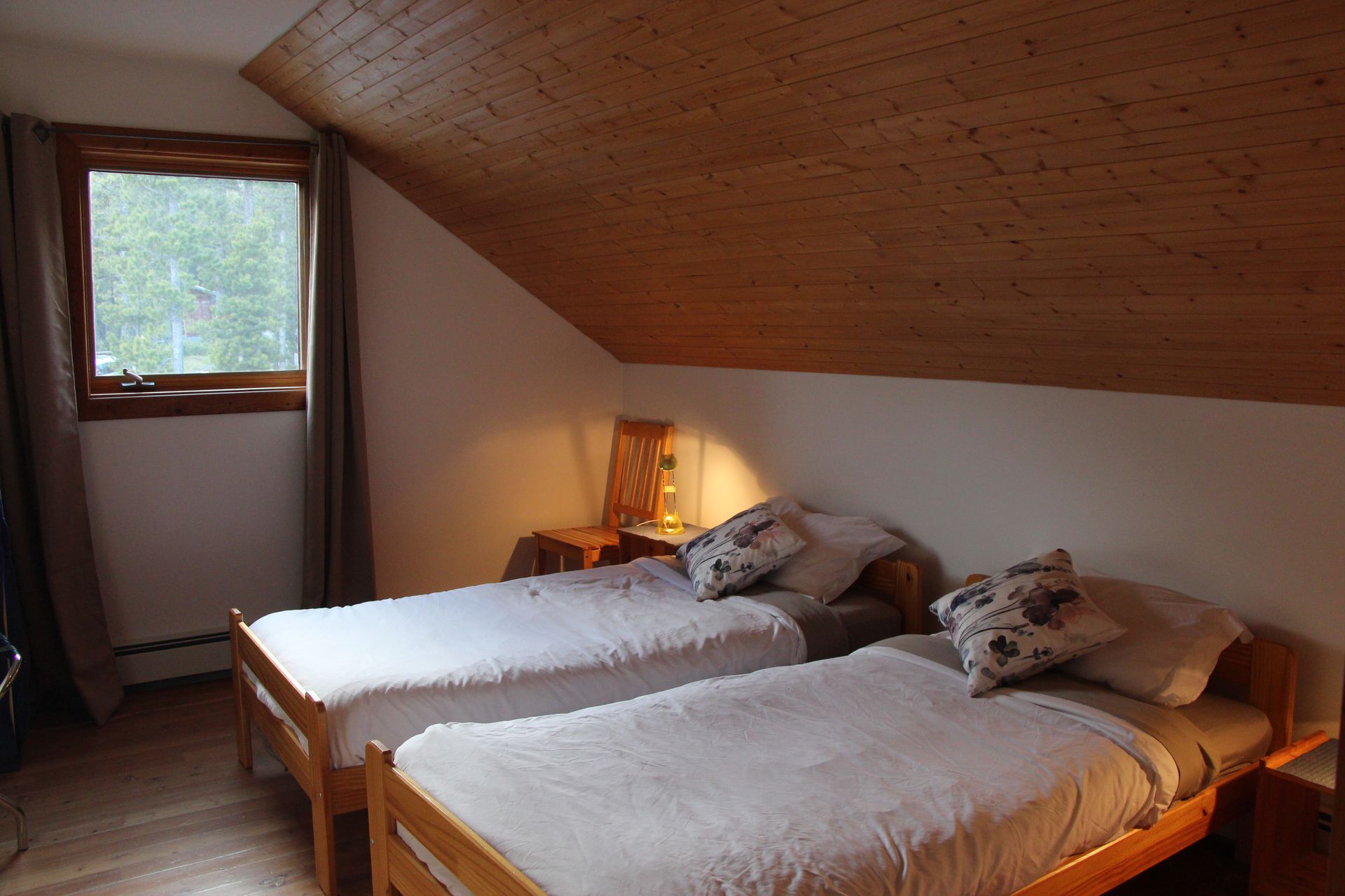 A bedroom with two twin beds and a window