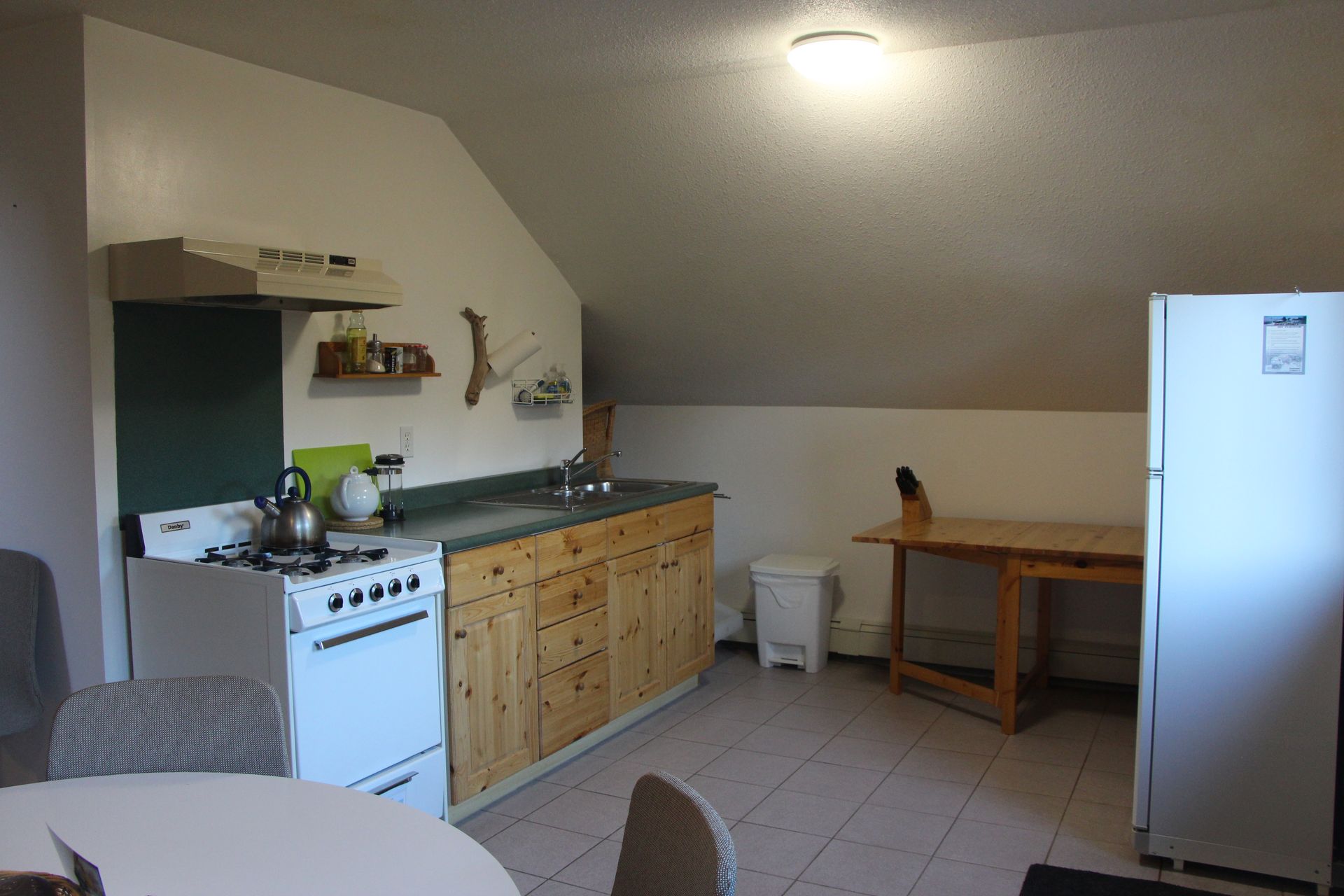 A kitchen with a white stove and a white refrigerator