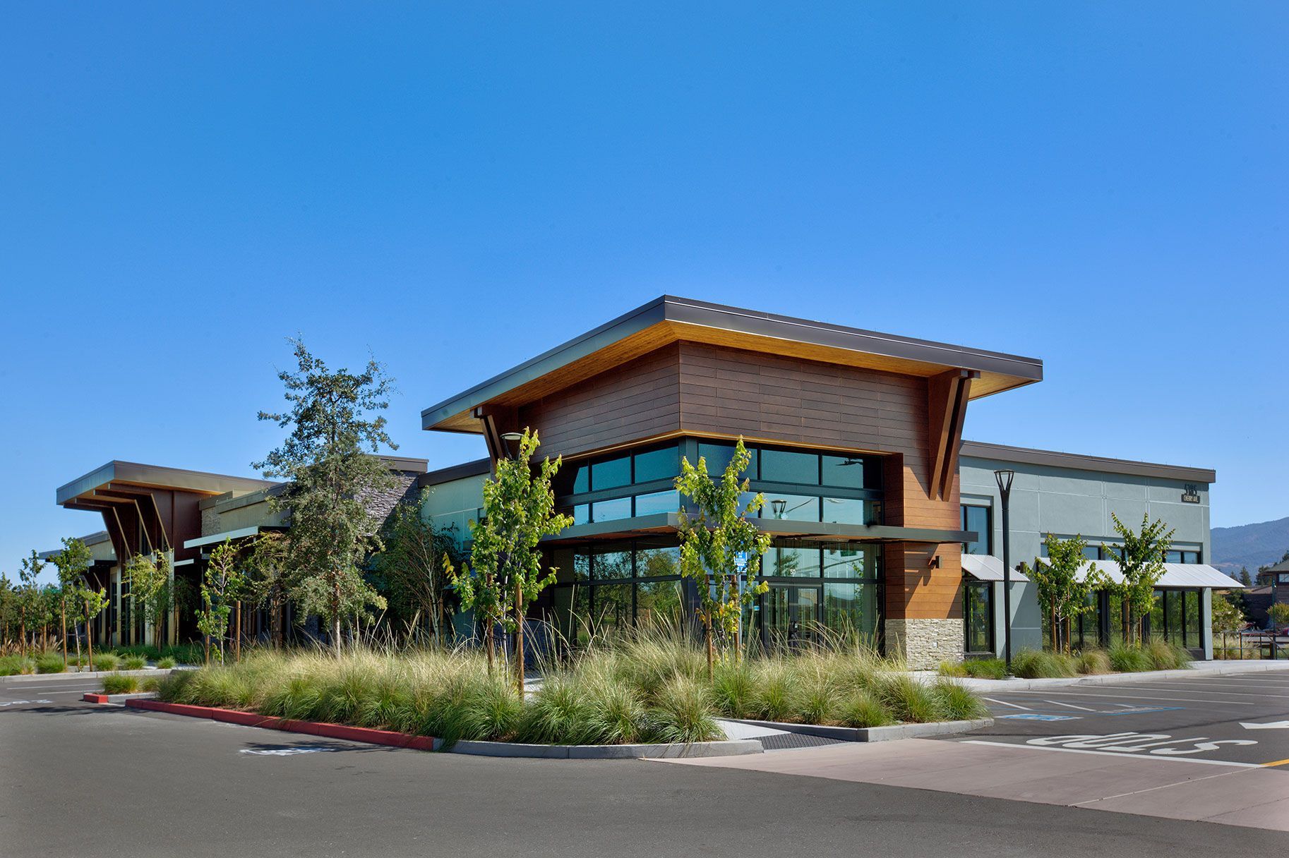 Modern building with wood and glass facade, blue sky.