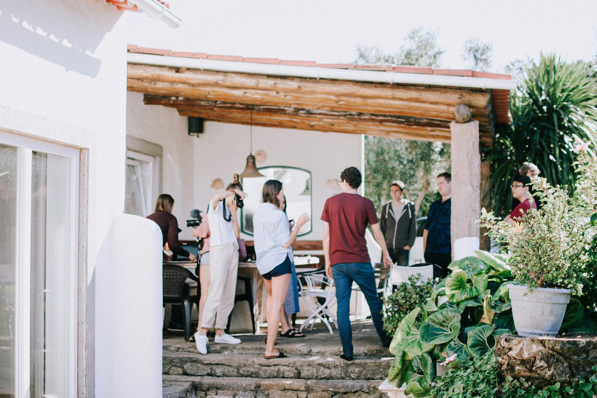 A group of people are standing on the steps of a house.