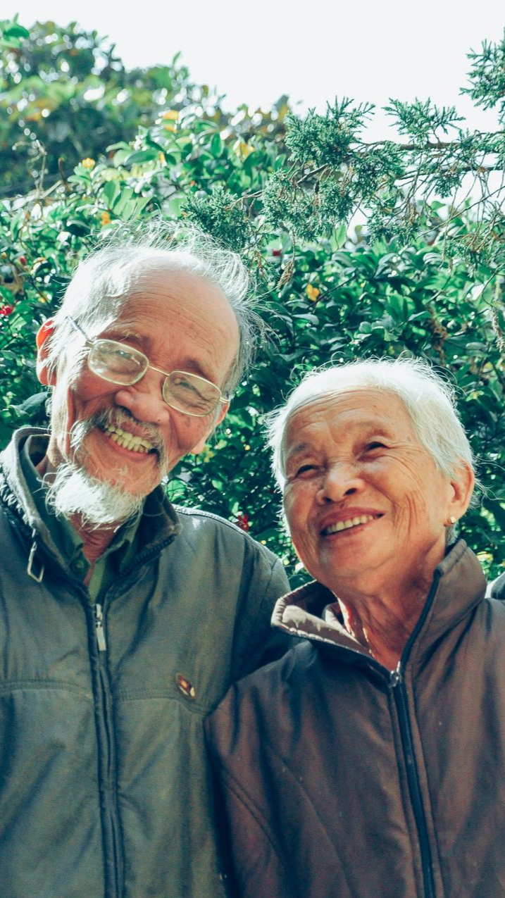 A family is walking down a sidewalk with a stroller.