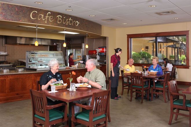 A group of people are sitting at tables in a cafe bistro