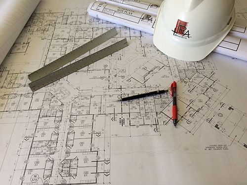 A hard hat is sitting on top of a blueprint.