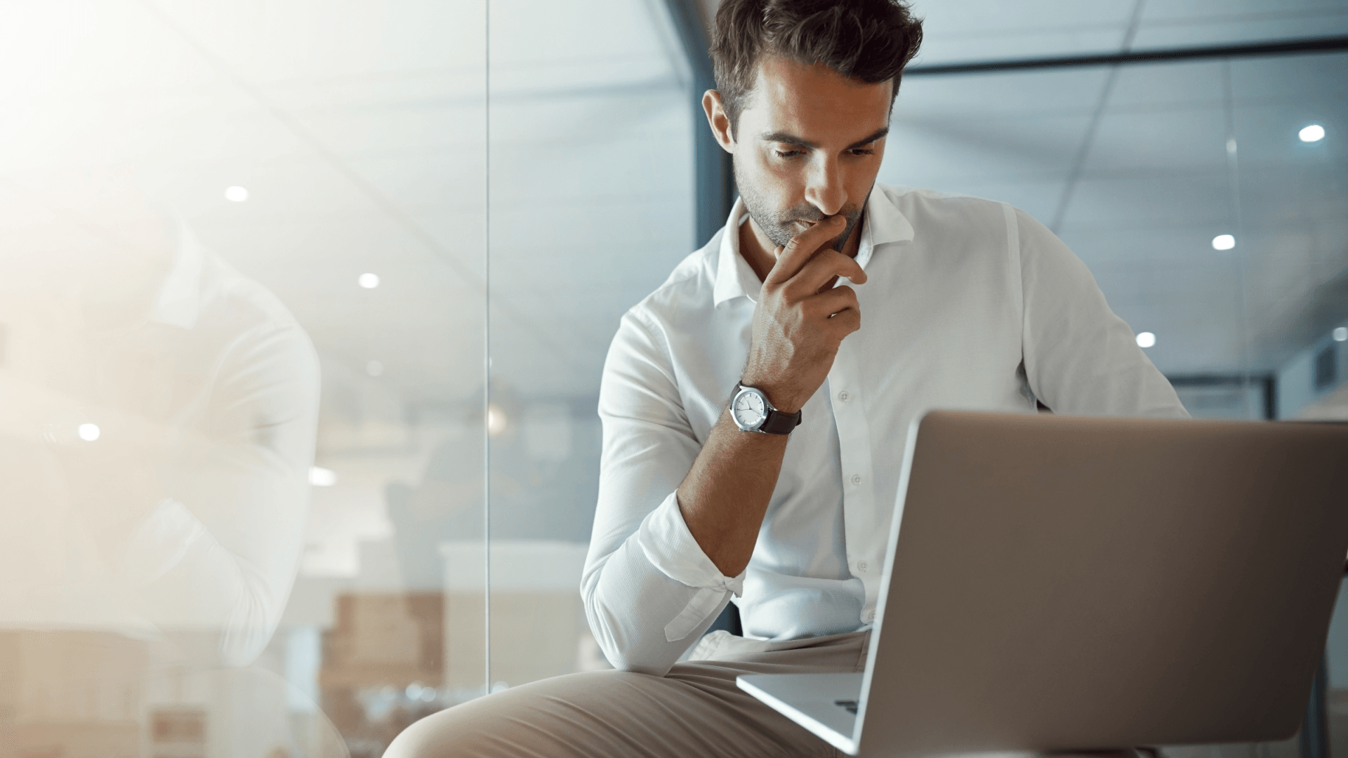 A man is sitting in front of a laptop computer.