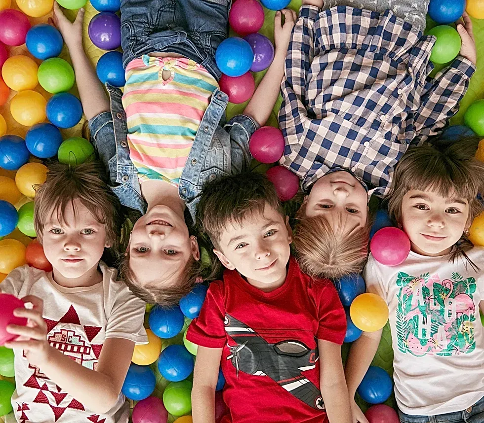 Young chilrdren laying on ground.