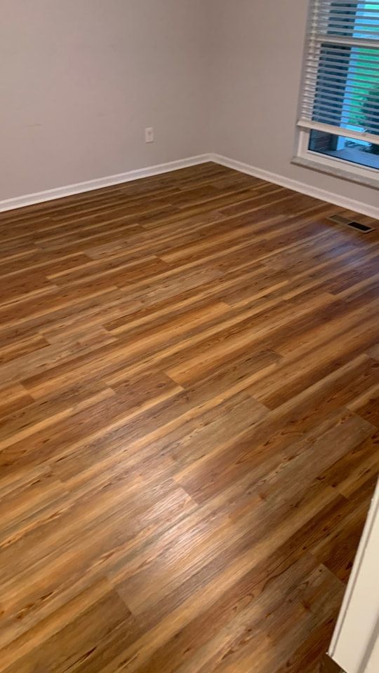 A living room with hardwood floors and a window.