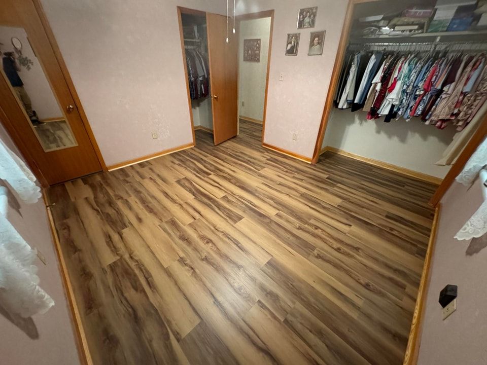 A bedroom with hardwood floors and a walk in closet.