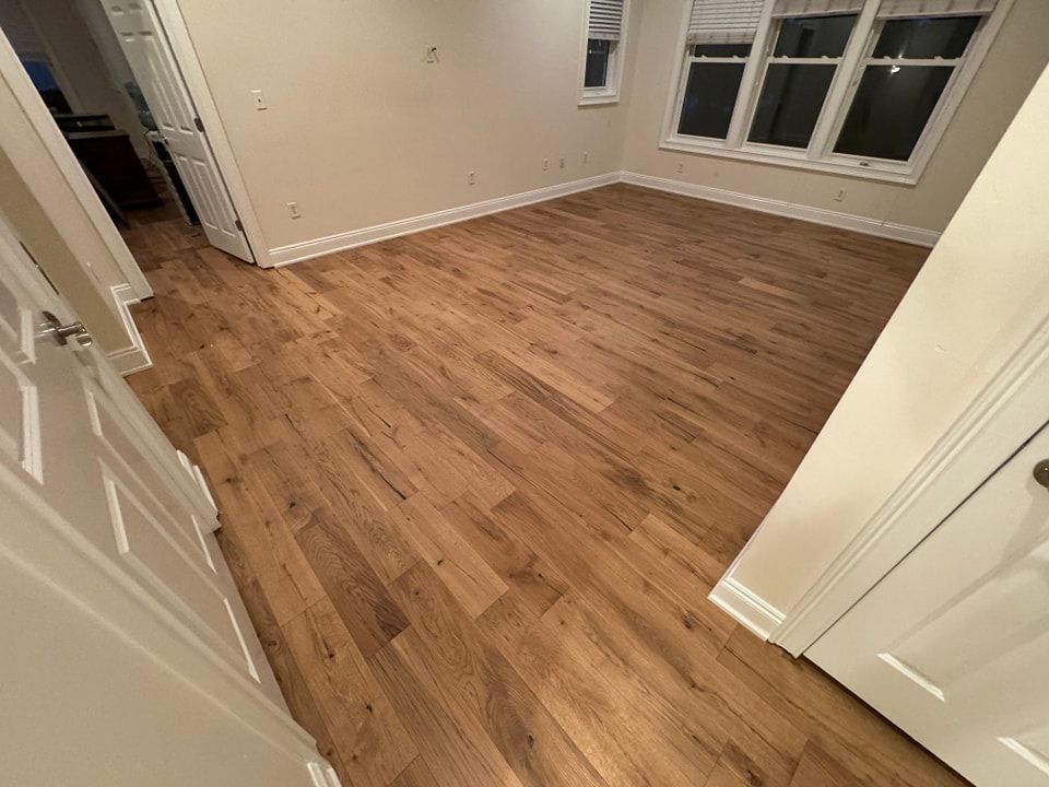 A room with hardwood floors and two windows.