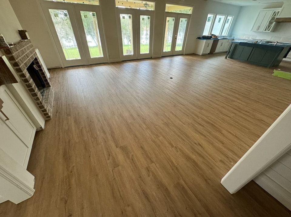 A living room with a wooden floor and a fireplace.