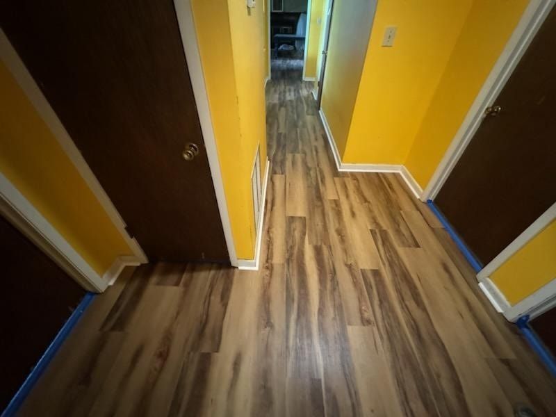 A hallway with hardwood floors and yellow walls