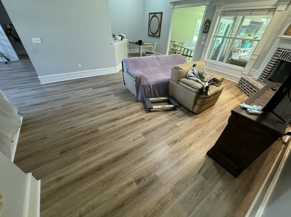 A living room with hardwood floors and a couch and chair.