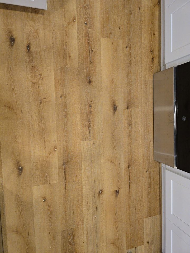 A kitchen with a wooden floor and white cabinets.