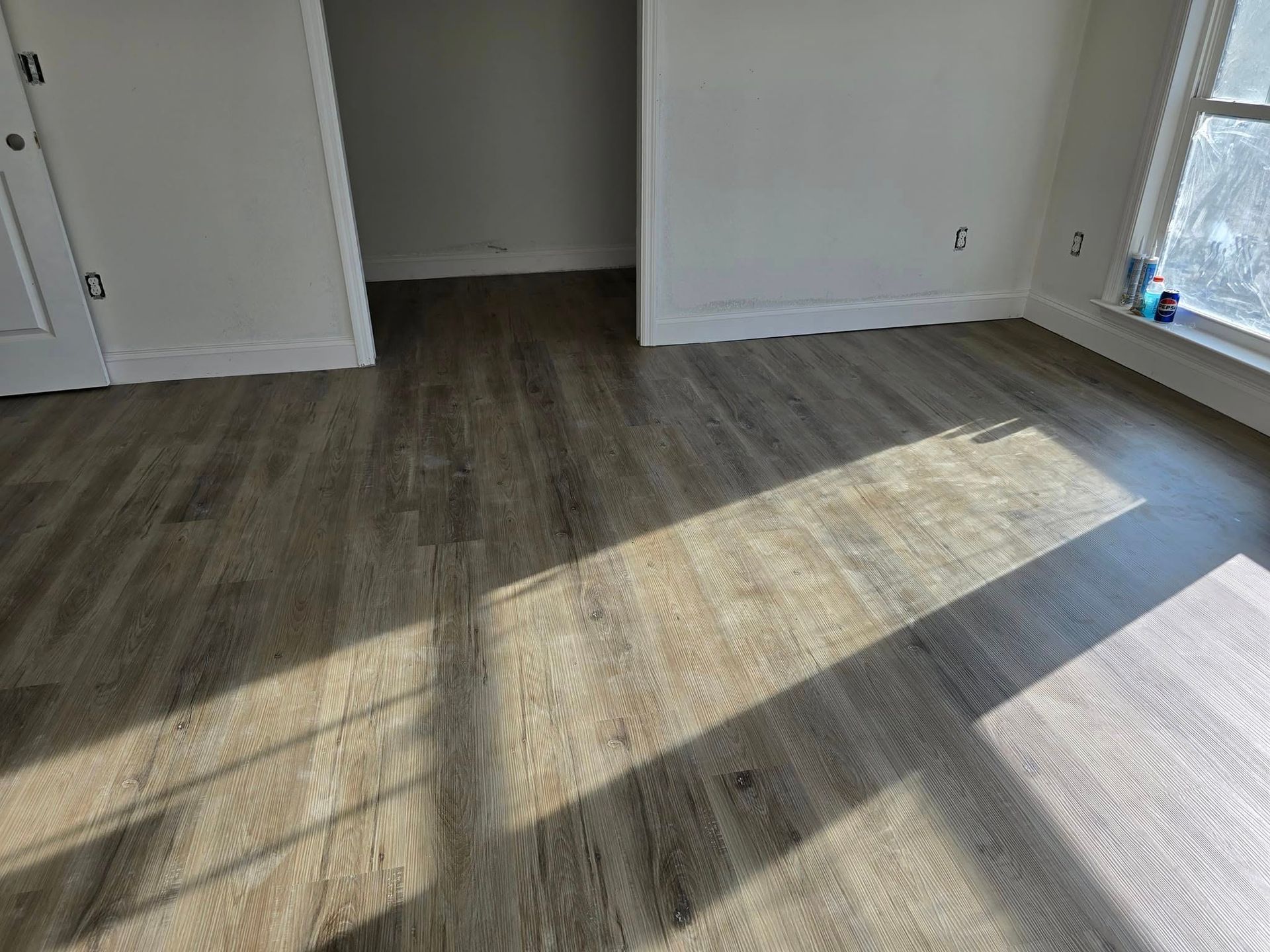 A room with hardwood floors and a window.