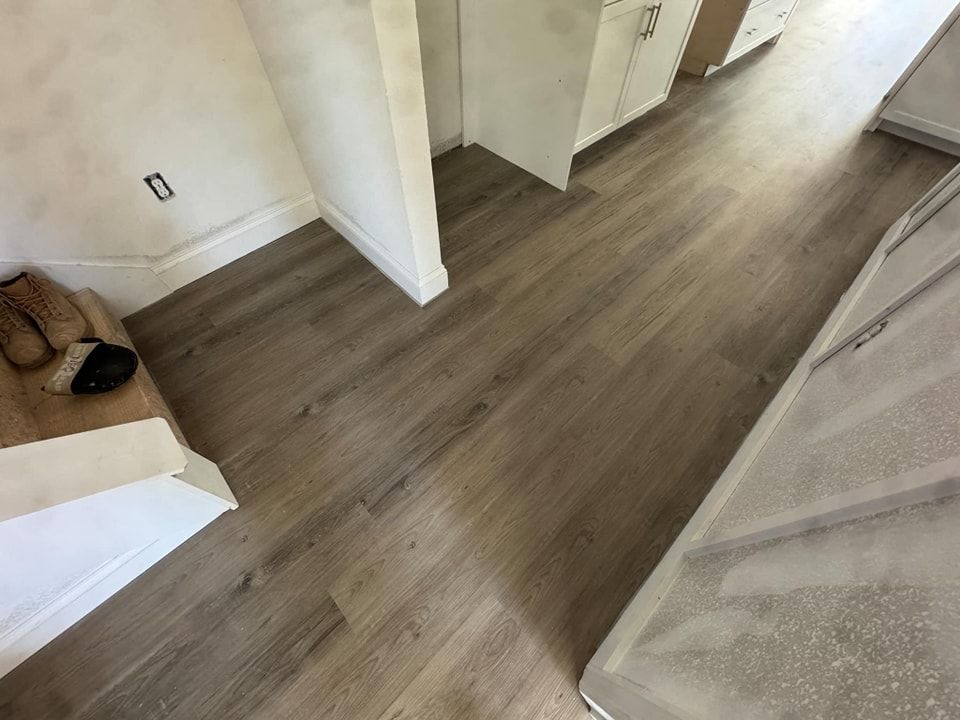 A hallway with a wooden floor and stairs in a house.