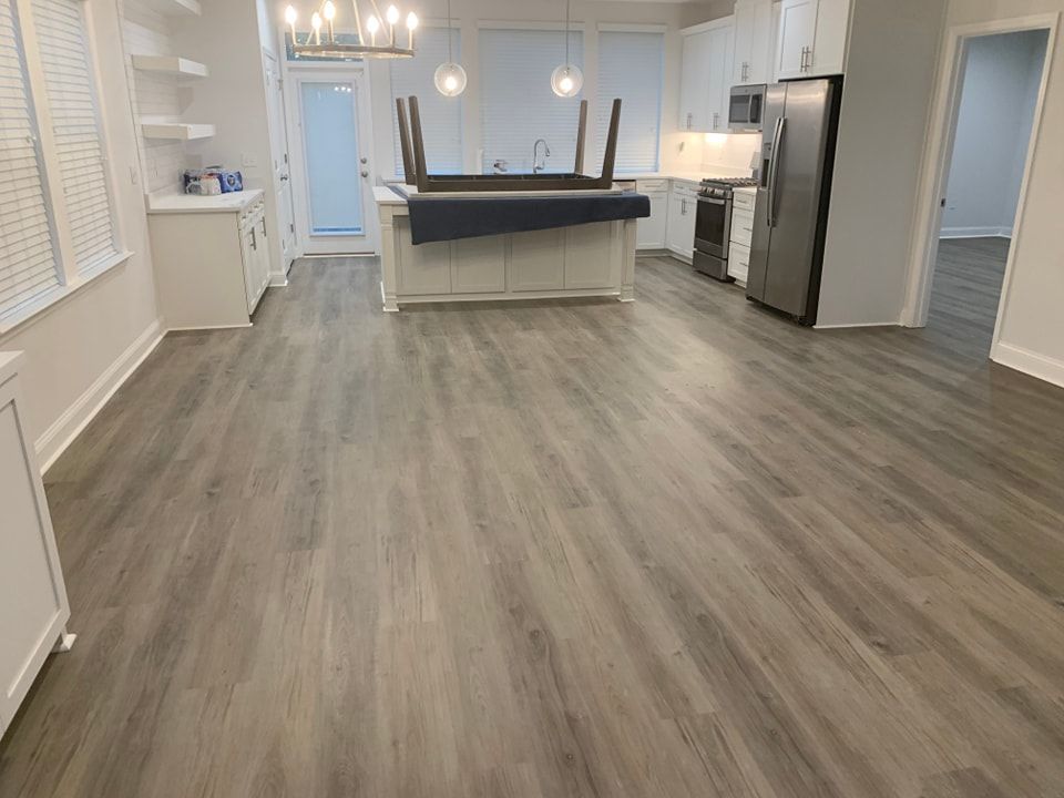 A kitchen with hardwood floors and white cabinets.