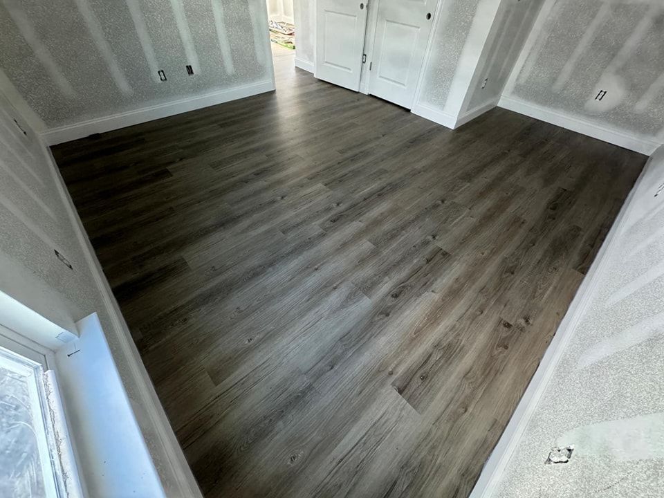 A room with a wooden floor and a window.