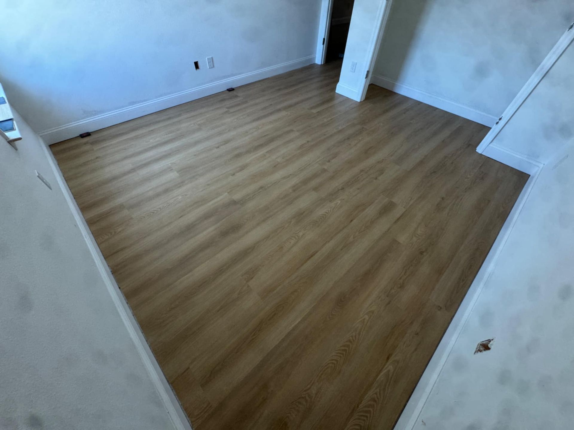 A room with a wooden floor and white walls.