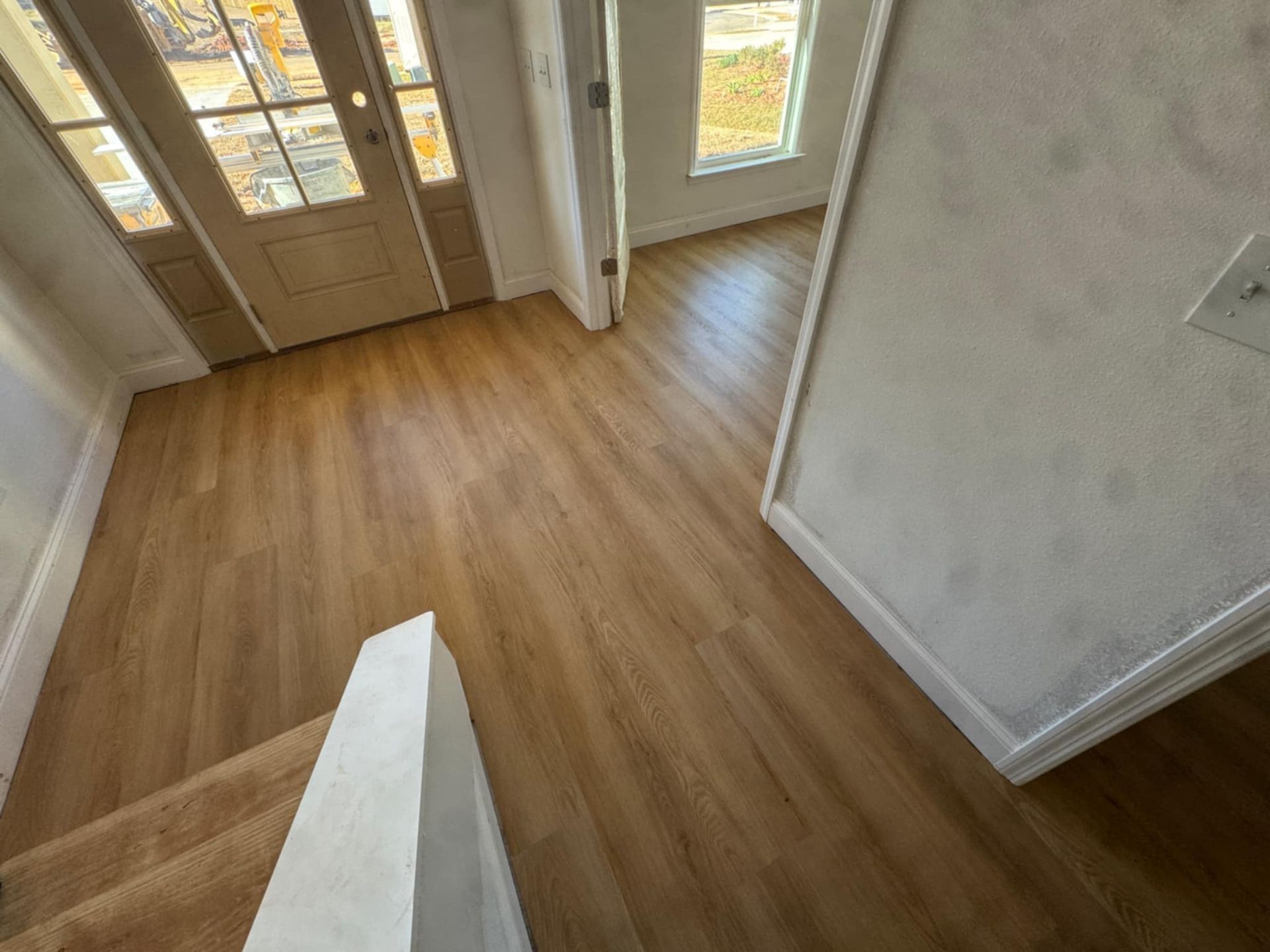 A hallway with hardwood floors and stairs in a house.