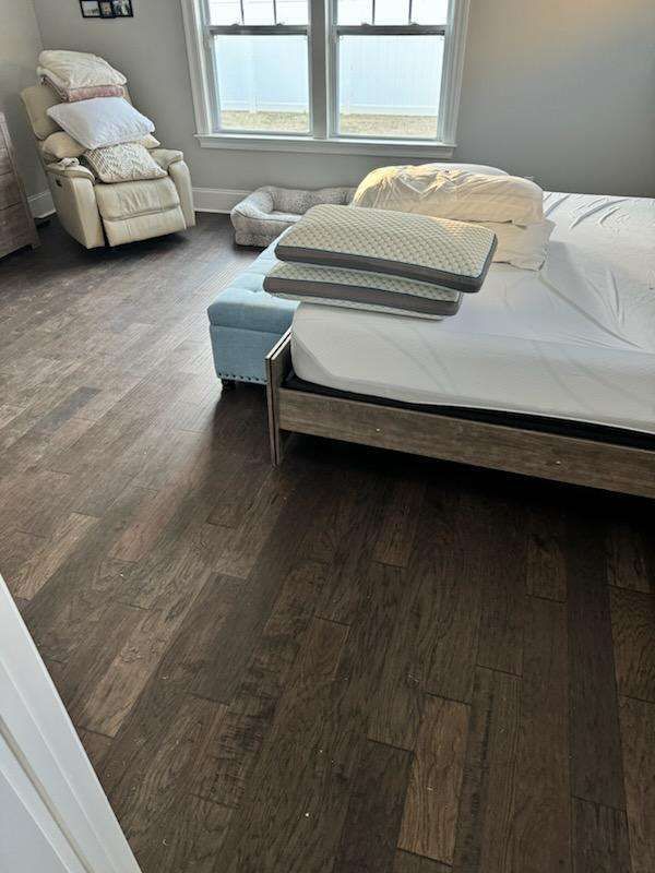 A bedroom with a bed , chair , and ottoman.