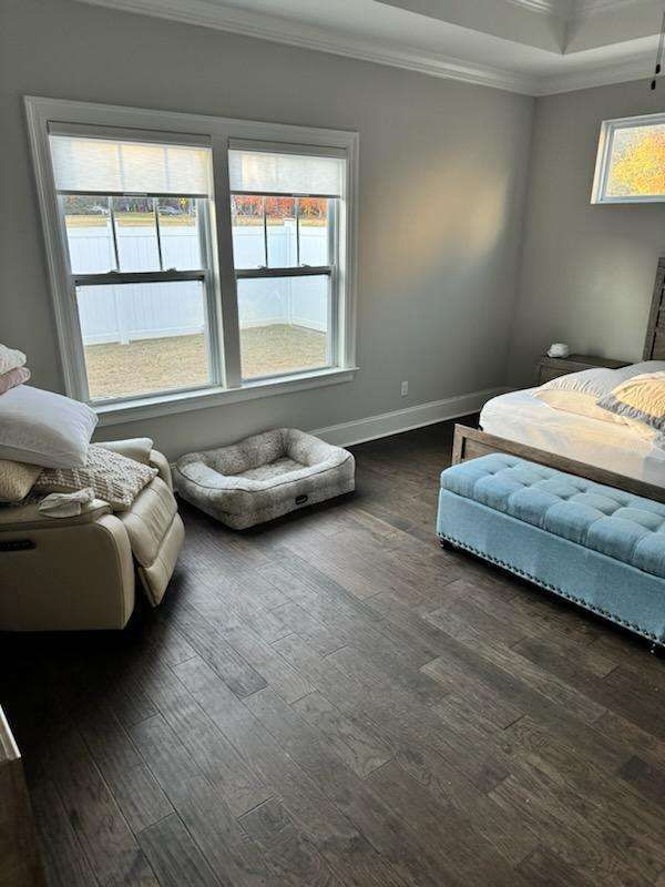 A bedroom with a bed , chair , and dog bed.