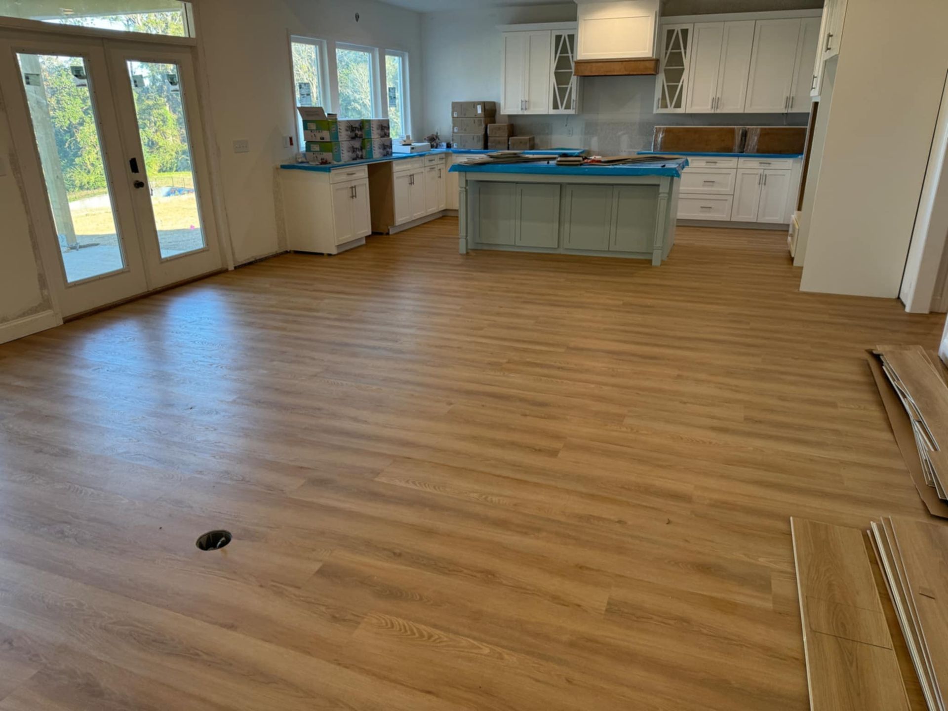 A kitchen with a wooden floor and white cabinets.