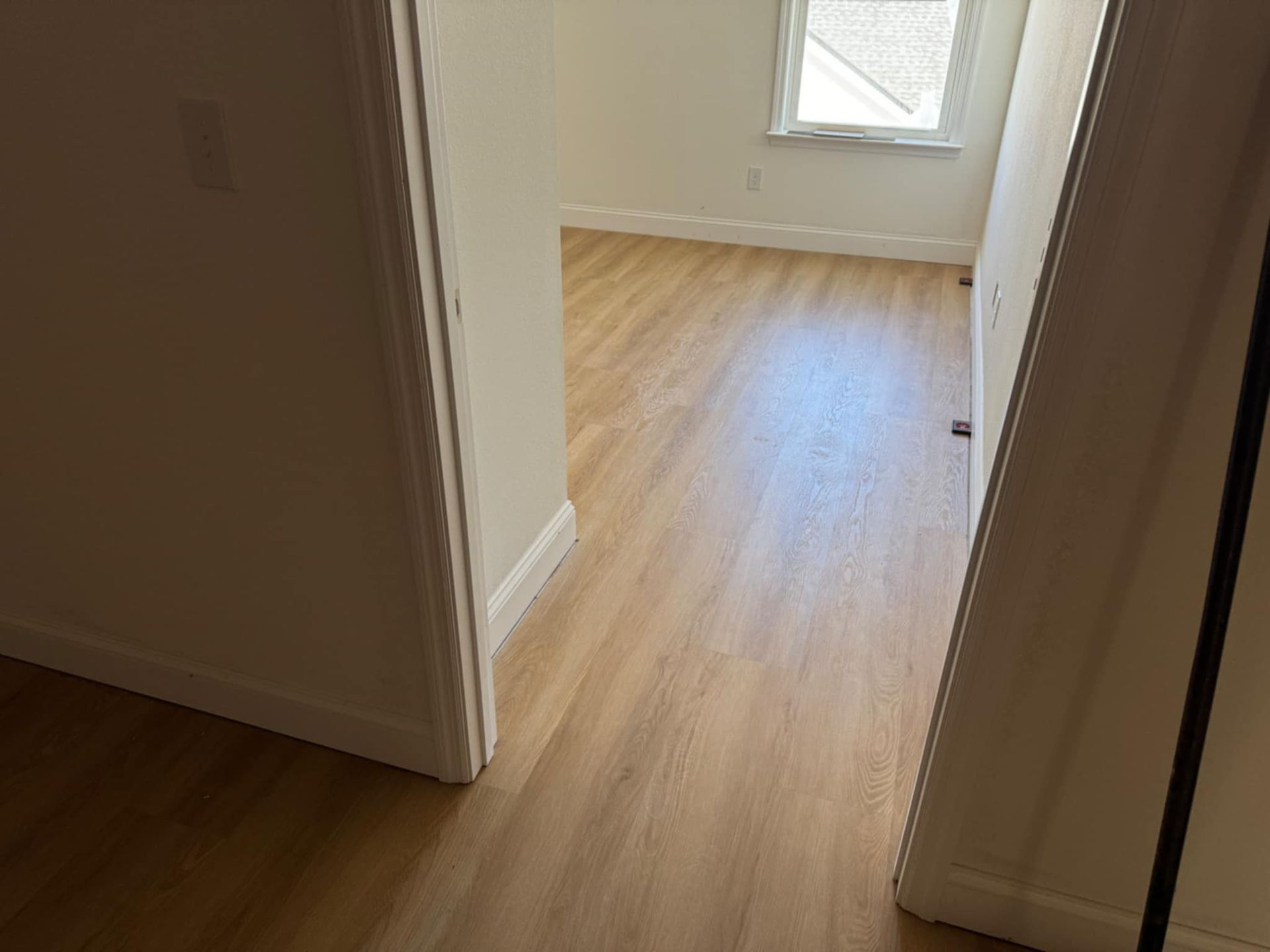 A room with hardwood floors and a window.
