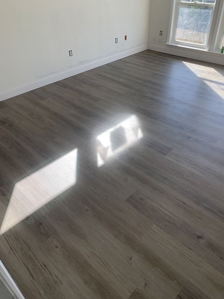 A living room with hardwood floors and a window.