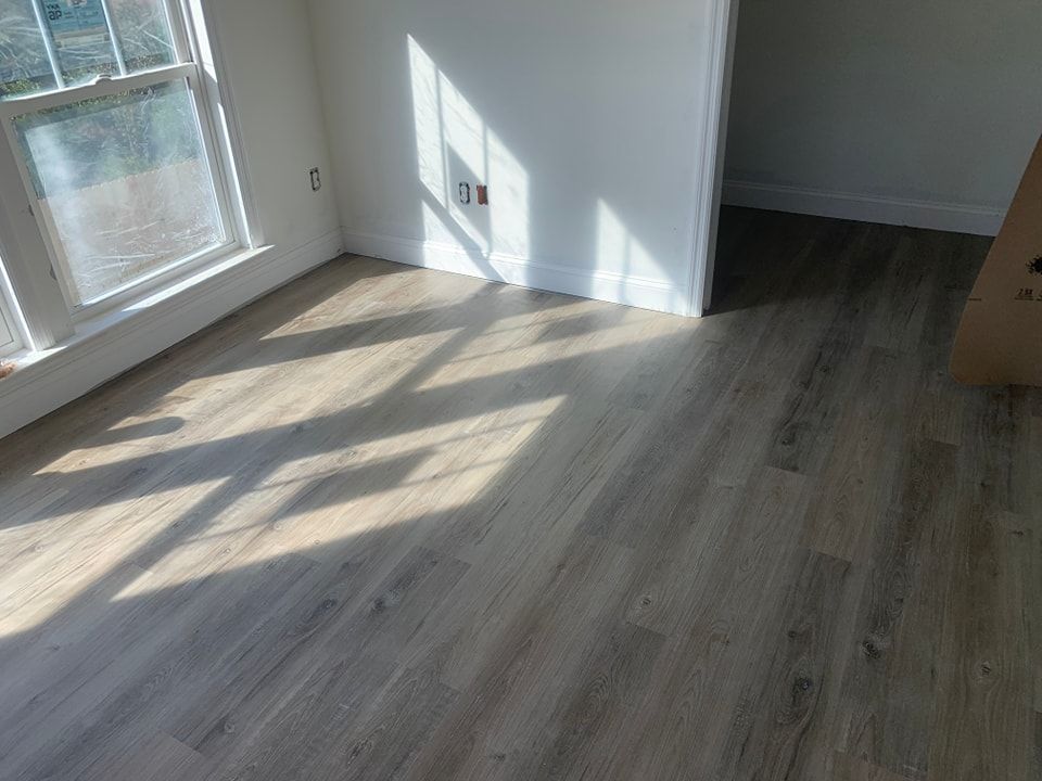 A room with a wooden floor and a window.