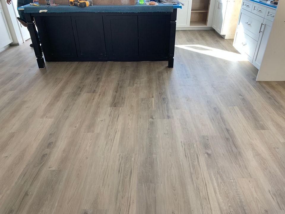 A kitchen with a wooden floor and a blue island.