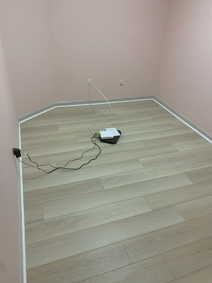 A room with a wooden floor and pink walls.