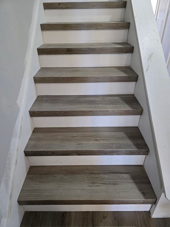A set of stairs with wooden steps and a white railing.
