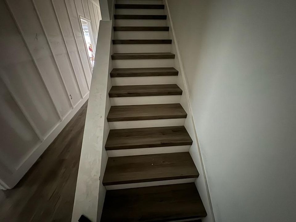 A set of wooden stairs leading up to the second floor of a house.