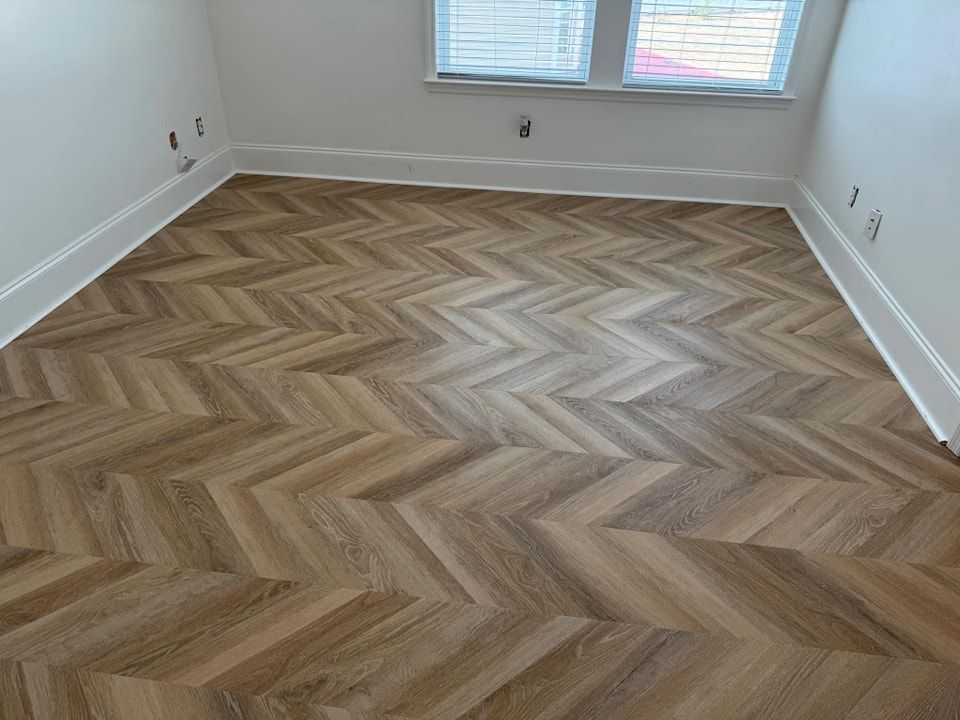 A room with a wooden floor and a herringbone pattern.