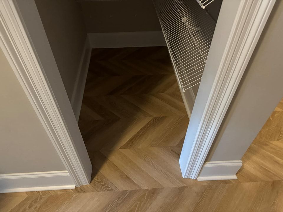 A closet with a wooden floor and a herringbone pattern