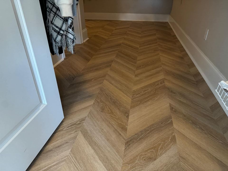 A wooden floor with a herringbone pattern in a closet.