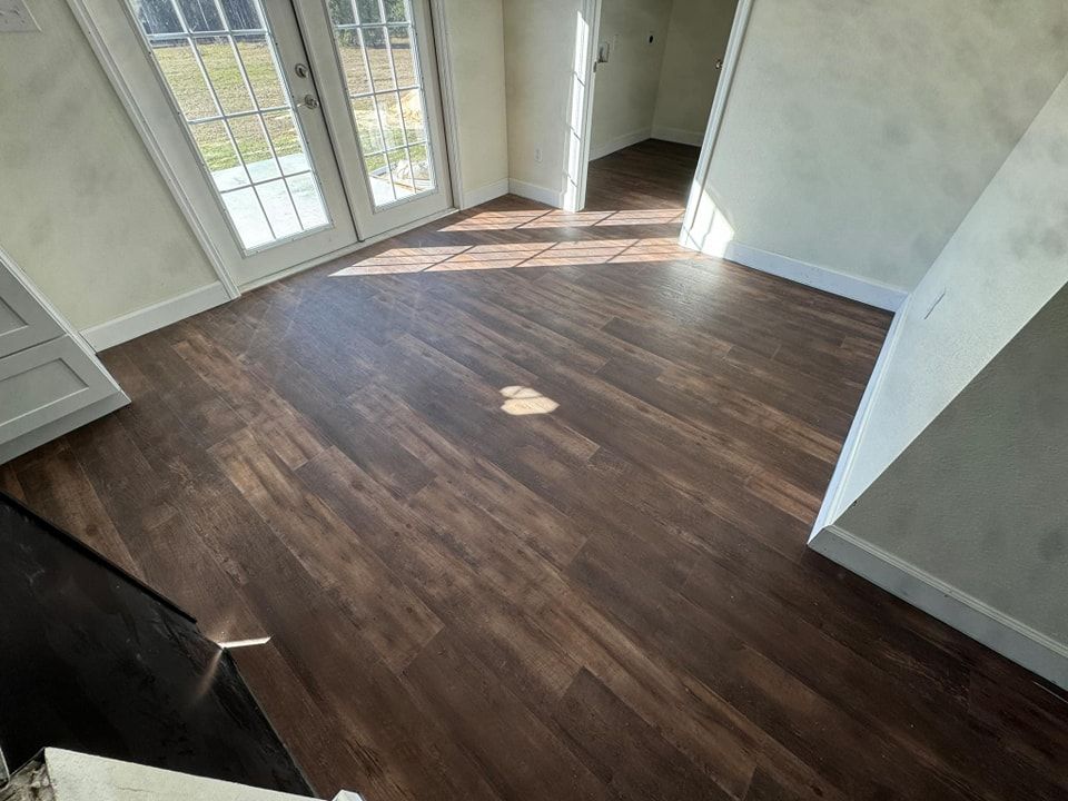 A room with a wooden floor and sliding glass doors.